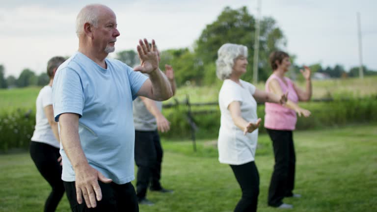 Adults practicing gentle TaiJi in a community center to improve balance and mobility