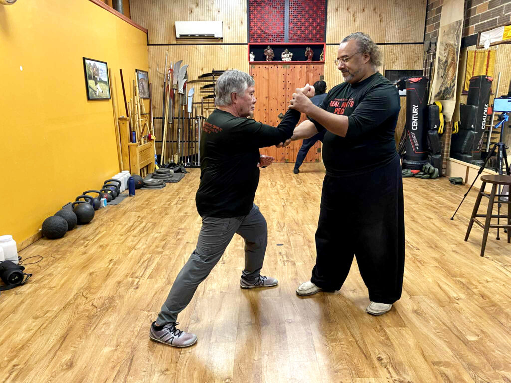 Martial arts instructor Marc Black helping adult student refine Kung Fu technique Pittsburgh PA.