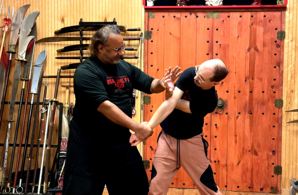 Marc Black guiding an adult martial arts student during Kung Fu training in Pittsburgh PA.