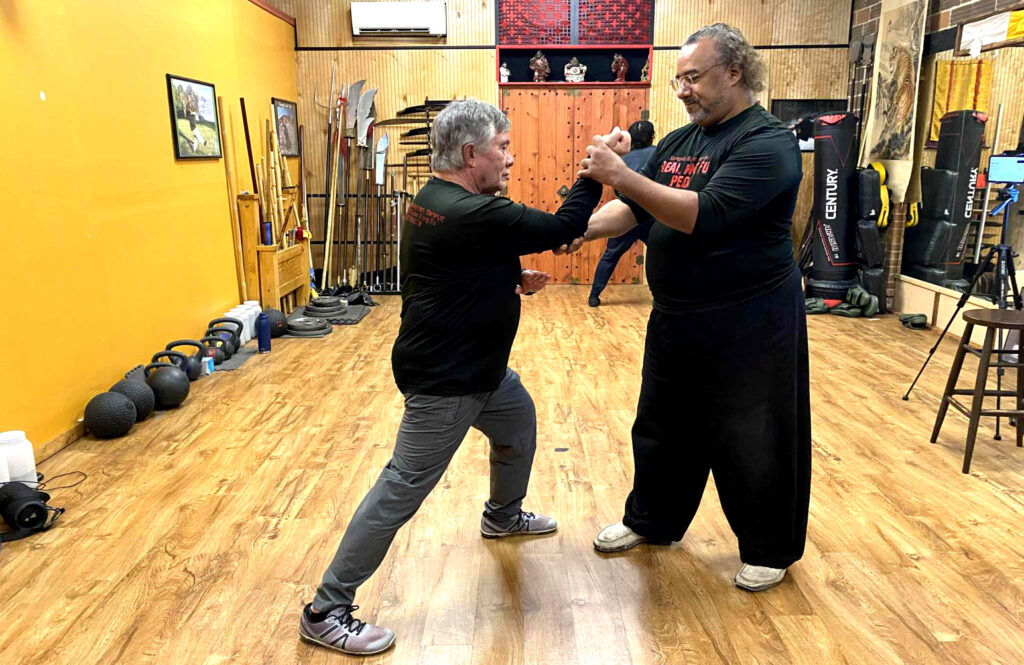 Martial arts instructor correcting student form during class at Black Mountain Spirit Pittsburgh.
